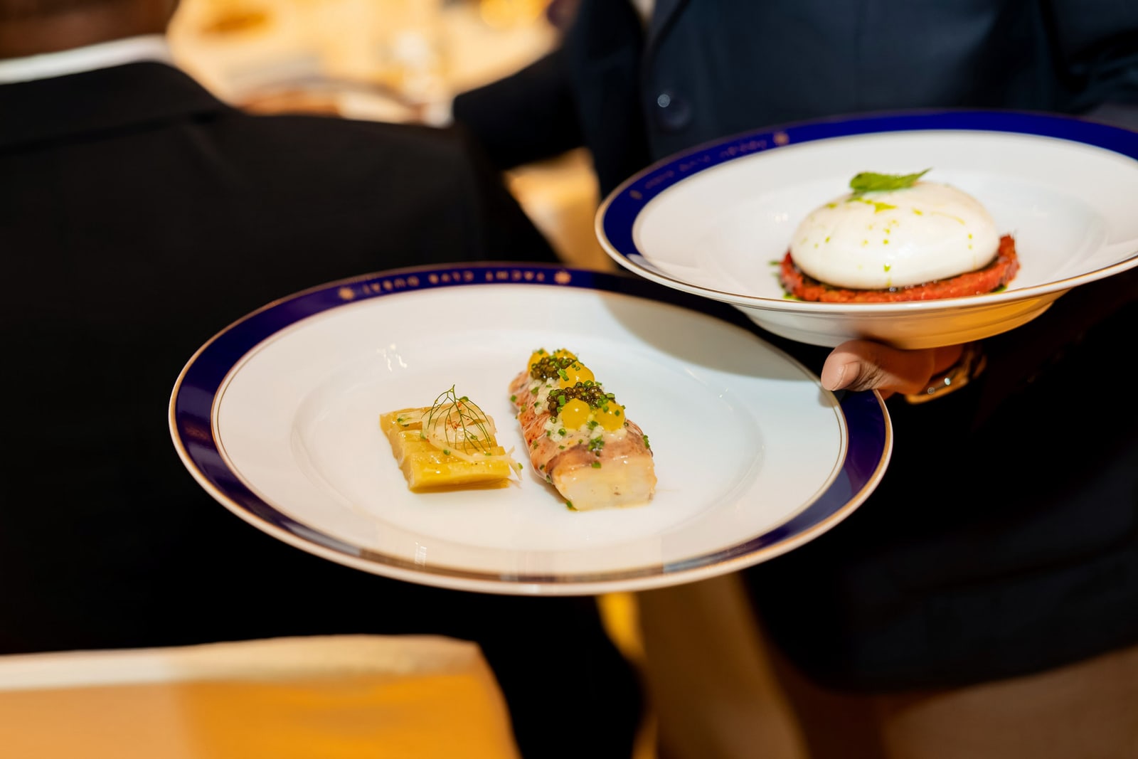 Fine dining plates carried through a dark room